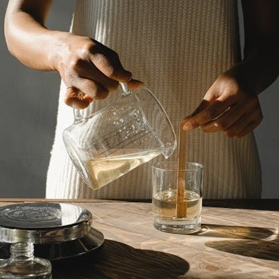wax being poured into container while learning how to make scented candles
